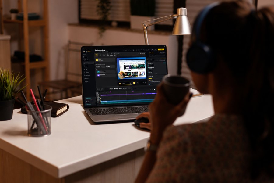 A creator recording an evening lesson in OurScreen, headphones on, coffee in hand